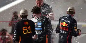 Oscar Piastri, Lando Norris és Max Verstappen pezsgőzve ünnepel a dobogón, F1 2025 Abu Dhabi