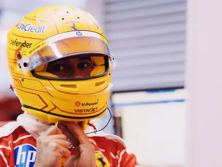 Lewis Hamilton becsatolja a sisakját