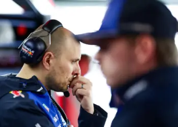 Gianpiero Lambiase, gondolkodó pózban. Az előtérben homályosam Max Verstappen
